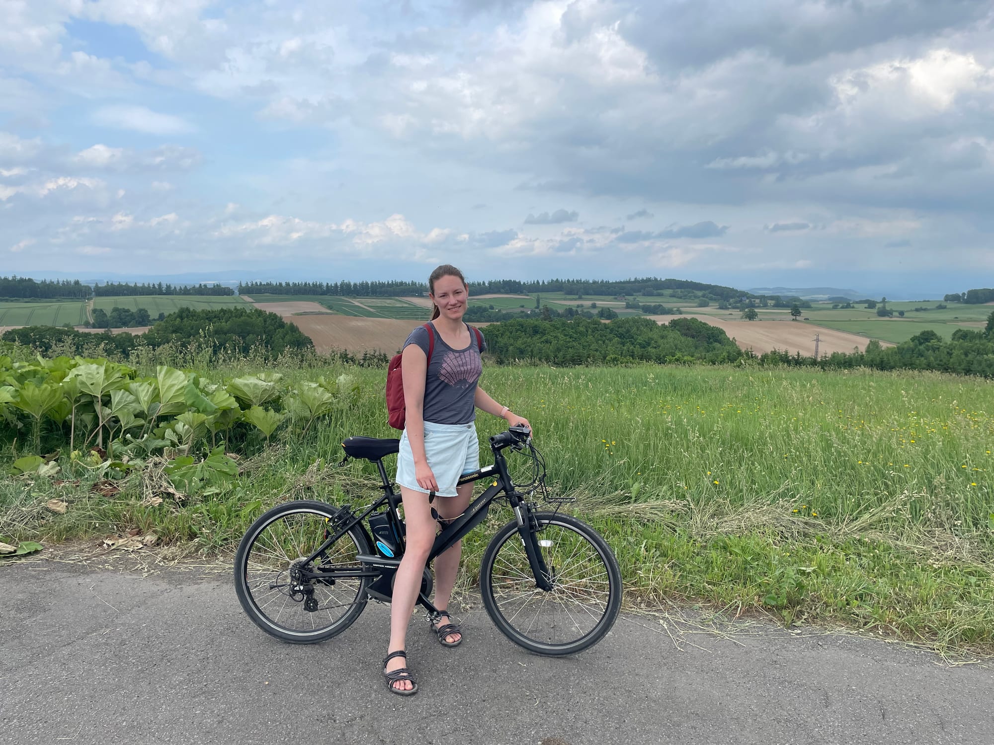 me on a bicycle. Behind me are rolling hills